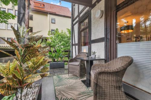 two chairs and a table on a balcony with plants at HIRSCH Stadt Apartment 1 - Terrasse mit Flussblick - Parkplatz in Bad Harzburg
