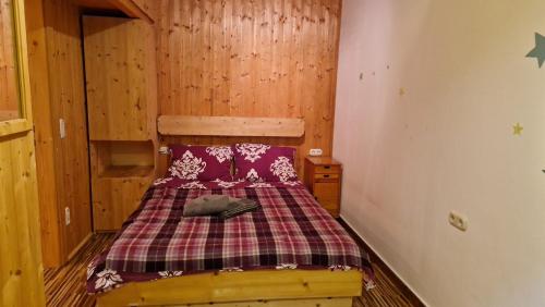 a small bedroom with a bed in a cabin at Innerkrems Apartment Mateja in Innerkrems