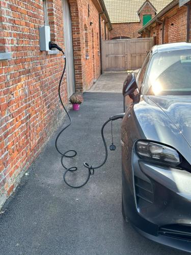 a car is parked next to a brick wall at ChienMarin Healthfarm & Residences Anno 1712 ***** in Nieuwpoort