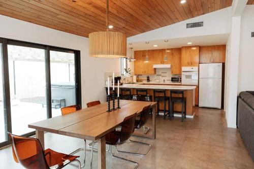 a kitchen and dining room with a wooden table and chairs at Schubert Haus - 2 BLKS to Main St Hot Tub & Pool in Fredericksburg