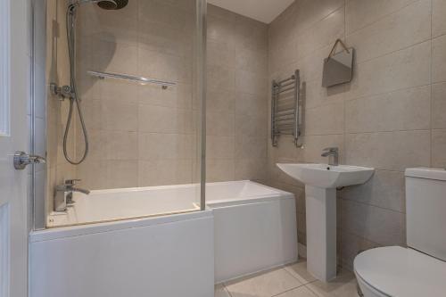 ein Badezimmer mit Badewanne, Toilette und Waschbecken in der Unterkunft Contractors Business Families Relocation Accommodation enjoy Fast WiFi Large Screen Smart TV and SKY Sports in this Spotless Ground Floor apartment in Wakefield