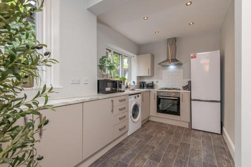 a kitchen with a white refrigerator and a dishwasher at Contractors Business Families Relocation Accommodation enjoy Fast WiFi Large Screen Smart TV and SKY Sports in this Spotless Ground Floor apartment in Wakefield