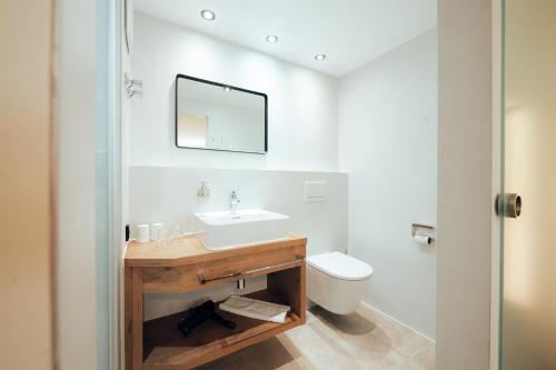 a bathroom with a sink and a toilet at Hotel Tradizio in Mittelberg
