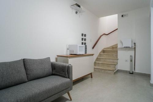 a living room with a couch and a staircase at HLive Consulado in Sao Paulo