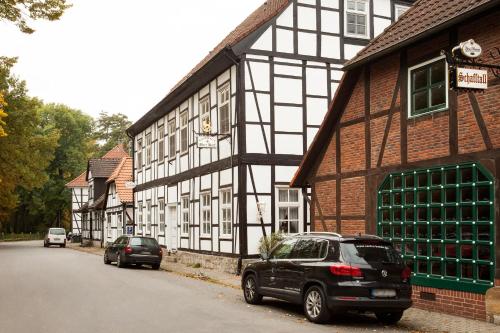a black and white building with cars parked in front of it at Hotel Alter Wolf in Wolfsburg