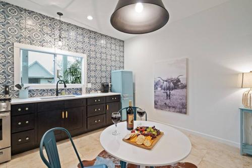 a kitchen with a table with a bowl of fruit and wine glasses at Stonewall Bungalow 3 - Sleeps 4 in Stonewall