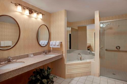 a bathroom with two sinks and a tub and a shower at Residence Inn by Marriott Saratoga Springs in Saratoga Springs