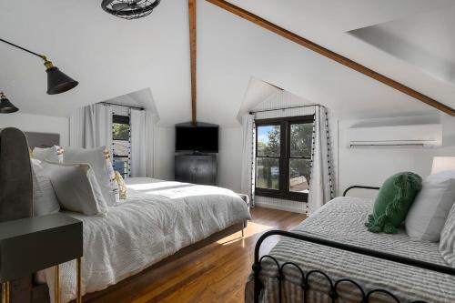 a white bedroom with two beds and a window at Stonewall Bungalow 4 - Sleeps 3 in Stonewall