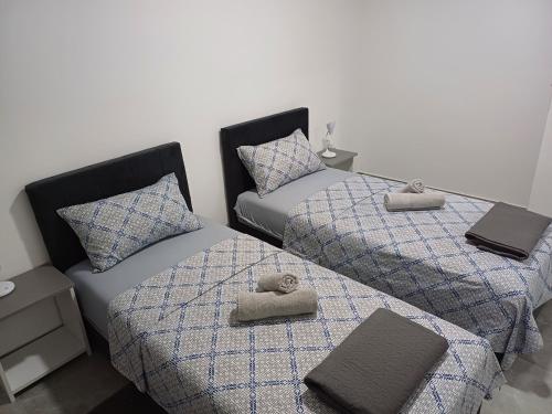 two beds with towels on top of them in a room at Prenoćište SILVER LUX Srebrno Jezero in Veliko Gradište