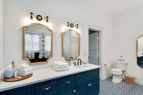 a bathroom with a sink with two mirrors and a toilet at Stonewall Main Haus - Sleeps 6 in Stonewall