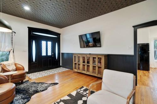 a living room with a chair and a tv at Stonewall Main Haus - Sleeps 6 in Stonewall