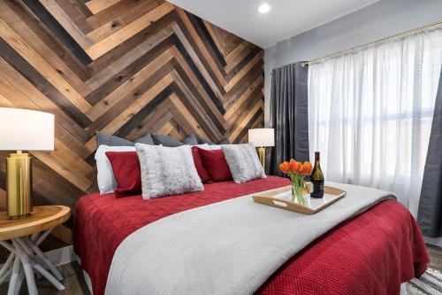 a bedroom with a red bed with a wooden wall at Strawberry Suite - Fire Pit BBQ Grill & more in Fredericksburg