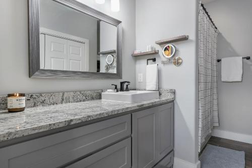 a bathroom with a sink and a mirror at Strawberry Suite - Fire Pit BBQ Grill & more in Fredericksburg