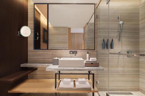 a bathroom with a sink and a shower at Courtyard by Marriott Goa Colva in Colva