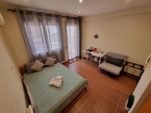 a bedroom with a bed with two towels on it at Astro Studio Apartments in Katerini
