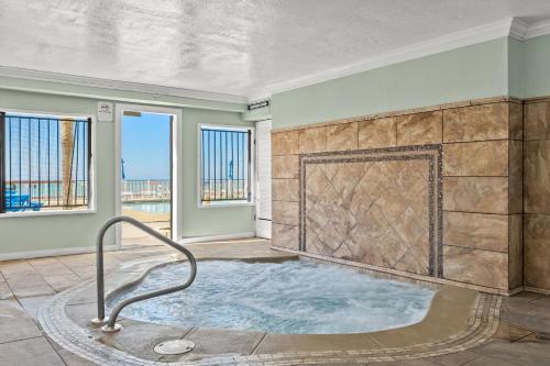 a jacuzzi tub in a room with windows at 4 Loungers 2 Umbrellas Inlc Peak Season Beachfront in Panama City Beach