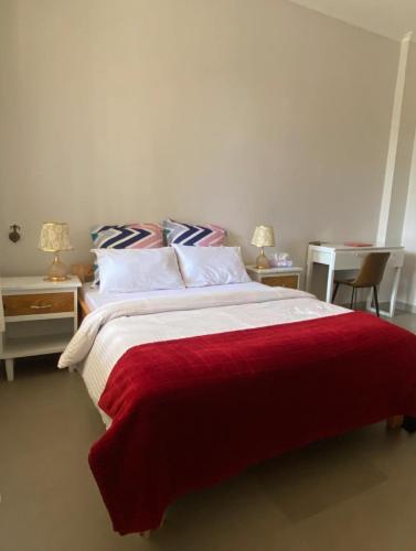 a bedroom with a large bed with a red blanket at Amazing home stays in Dar es Salaam