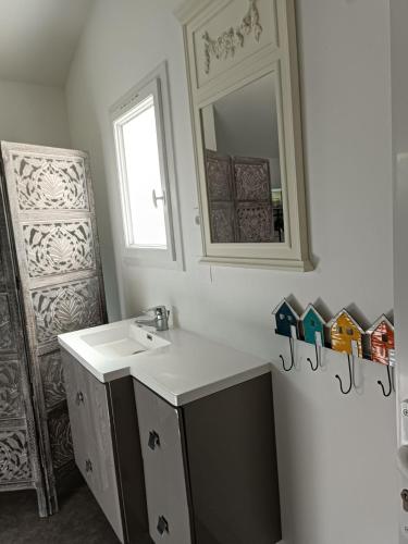 une salle de bain avec un lavabo et un miroir dans l'établissement Maison à la Brée, à La Brée-les-Bains