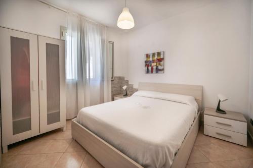a white bedroom with a bed and a window at Villa Danilo - Sicilia Vacanza in Avola