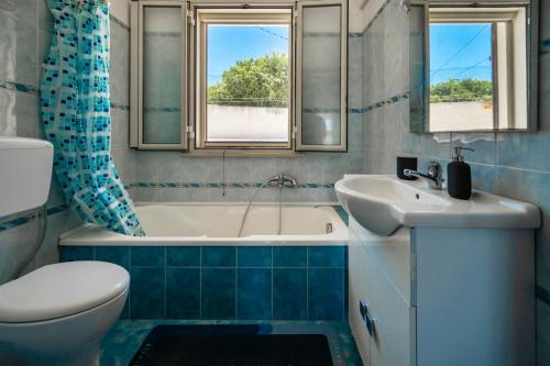 a bathroom with a tub and a sink and a toilet at Villa Danilo - Sicilia Vacanza in Avola