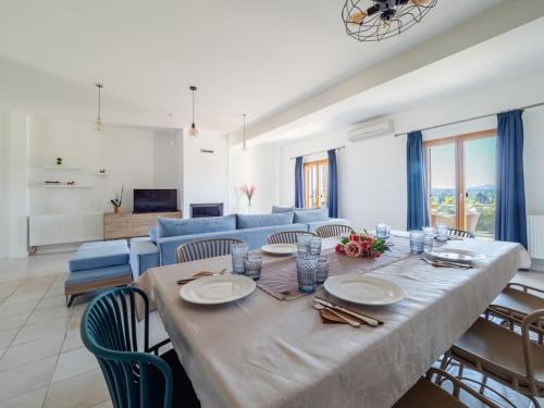 a living room with a table and a blue couch at Villa Althea 1 in Kompítsion