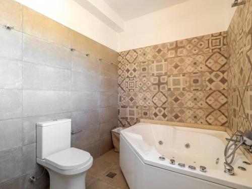 a bathroom with a tub and a toilet and a bath tub at Villa Althea 1 in Kompítsion