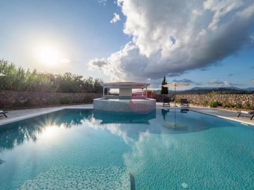 a large blue swimming pool with a gazebo at Villa Althea 1 in Kompítsion