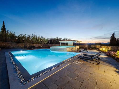 a large swimming pool with a patio at Villa Althea 1 in Kompítsion