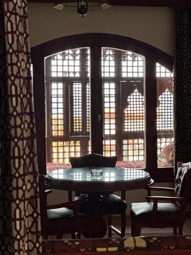 a table and chairs in a room with windows at Ali Baba Hotel in Dahab