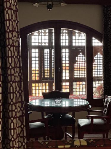 a table and chairs in a room with windows at Ali Baba Hotel in Dahab