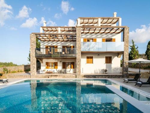 a villa with a swimming pool in front of a house at Villa Althea 1 in Kompítsion