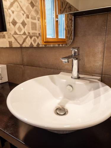 a white sink in a bathroom with a mirror at Villa Althea 1 in Kompítsion