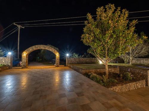 an archway in a park at night with lights at Villa Althea 1 in Kompítsion