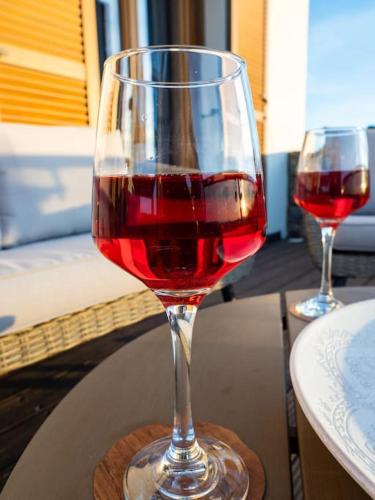 two glasses of red wine sitting on a table at Villa Althea 1 in Kompítsion