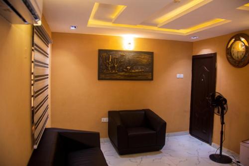 a room with a chair and a clock on the wall at draysapartments in Ibadan