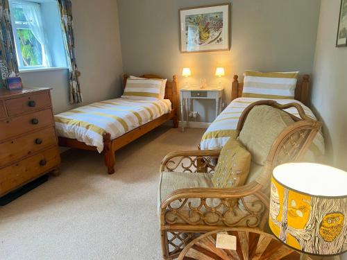 a small bedroom with two beds and a chair at Coastal Hidden Gem - Twin en-suite room with garden in Wells next the Sea