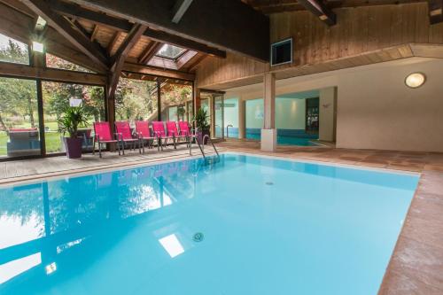 - une piscine dans une maison avec des chaises rouges dans l'établissement Hotel Club Le Crêt, à Morzine