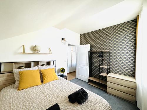 une chambre avec un grand lit avec des oreillers jaunes dans l'établissement Le Tropical- Beau T2 à 5min du centre-ville, à Annecy