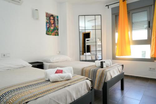 a room with two beds and a mirror at New Art Hostel - Albergue Juvenil in Palma de Mallorca