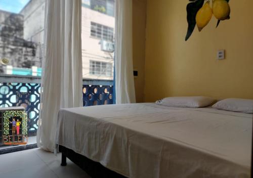 a bedroom with a bed and a large window at Belem Hostel in Belém