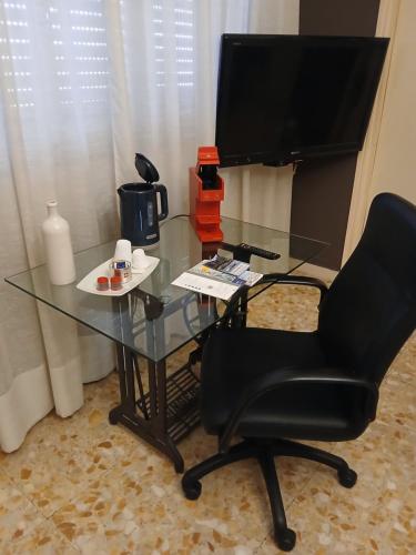a glass table with a chair and a television at vigne 5 in Brunate