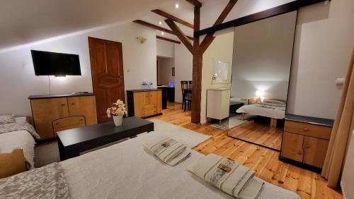 a large room with a bed and a living room at Aven'a pokoje gościnne z basenem in Darłowo