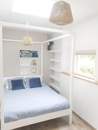 - une chambre avec un lit superposé blanc et des oreillers bleus dans l'établissement Bleu Azur - Trégor, à Ploubezre