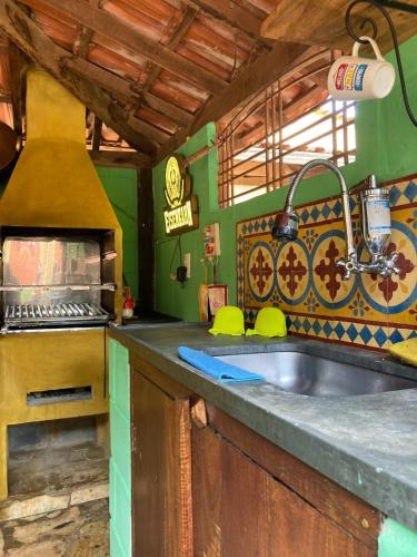 a kitchen with a sink and a stove at Pousada casa de fadas in Tiradentes