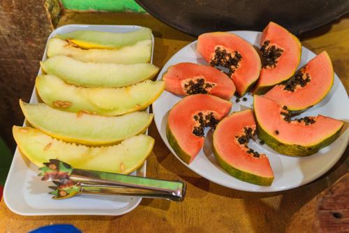 a plate of fruit on a wooden table at Pousada casa de fadas in Tiradentes