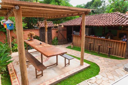 a patio with a wooden table and a bench at Pousada casa de fadas in Tiradentes
