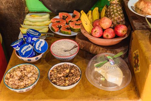 a table topped with bowls of fruit and nuts at Pousada casa de fadas in Tiradentes