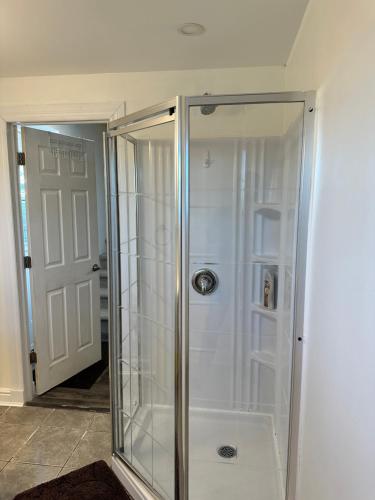 une douche avec une porte vitrée dans une salle de bain dans l'établissement Central Halifax one Bedroom apartment in Clayton Park, à Halifax