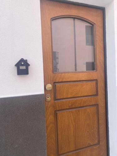 a wooden door with a window on a wall at Corte ‘e susu in Nuoro