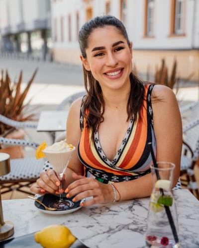a woman sitting at a table with a drink at GRAND CENTRAL LJUTOMER in Ljutomer